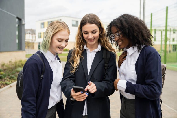 Three school friends looking at a phone together